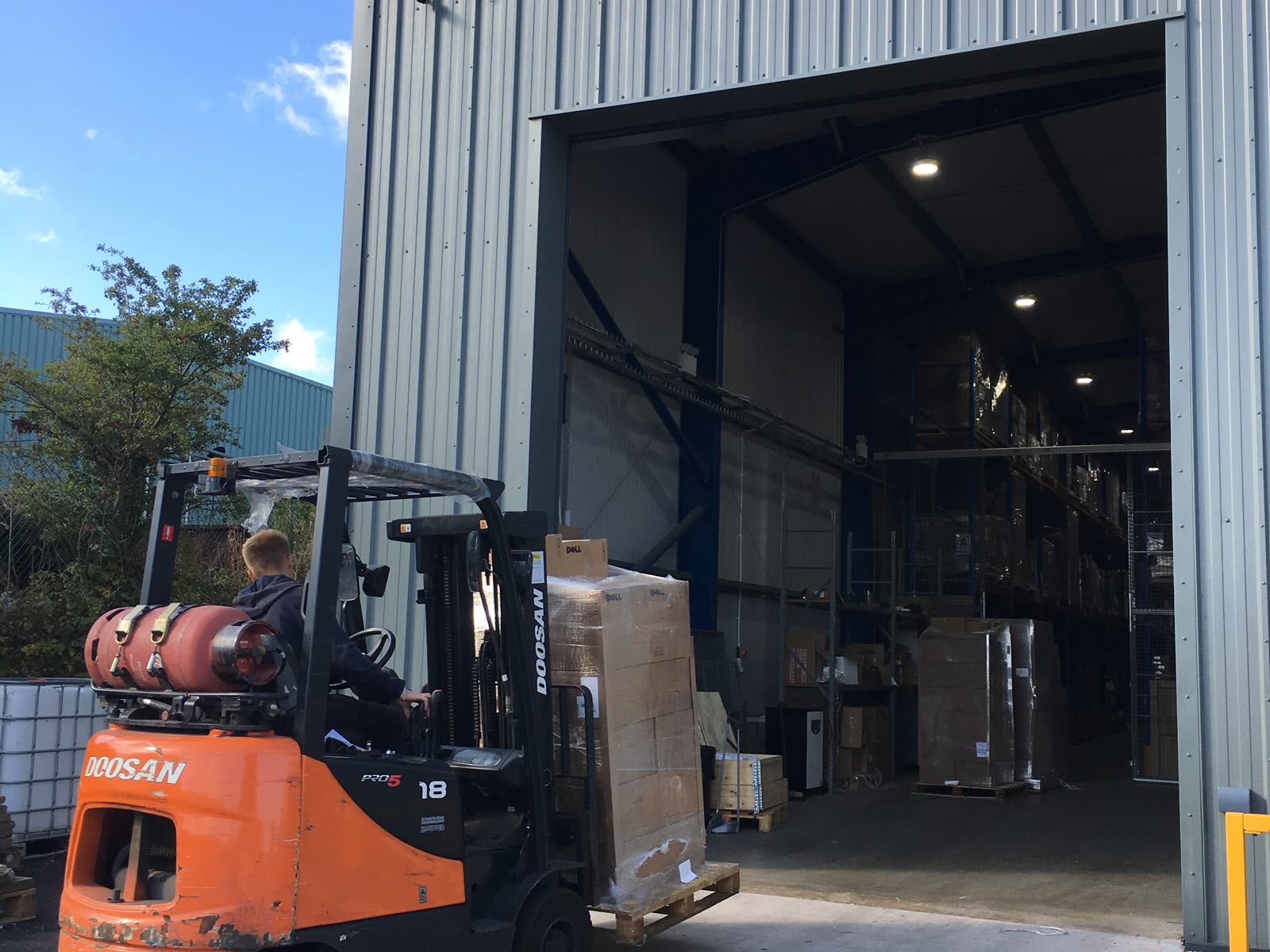 A forklift moving wrapped pallets in the Greensafe warehouse during a collection run